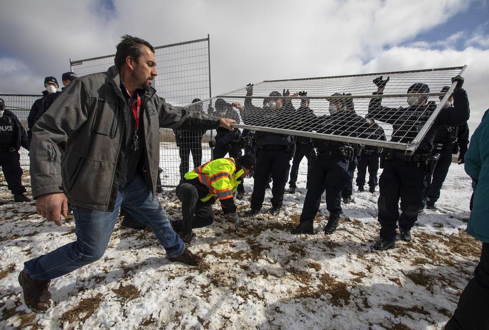Supporters try to tear down the fence as police struggle with them outside GraceLife Church near Edmonton, Alta., on Sunday, April 11. The church had been fenced off by police and Alberta Health Services in violation of COVID-19 rules.