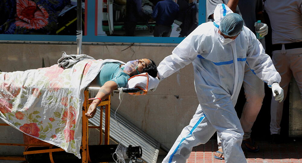 FILE PHOTO: A health worker wearing personal protective equipment (PPE) carries a patient suffering from the coronavirus disease (COVID-19) outside the casualty ward at Guru Teg Bahadur hospital, in New Delhi, India, 24 April 2021.