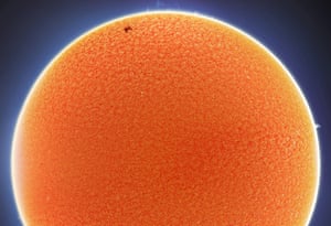 The International Space Station moves in front of the sun