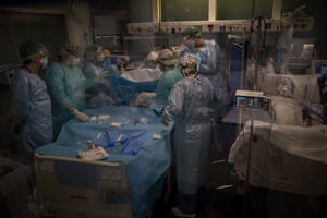 Doctors perform a tracheostomy on a Covid-19 patient in critical care at Hospital del Mar in Barcelona, Spain