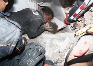 Rescue workers surround a girl rescued from the rubble of a collapsed building in İzmir, Turkey