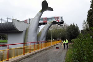 A metro train balances on the plastic tail of a whale sculpture in Spijkenisse, Netherlands