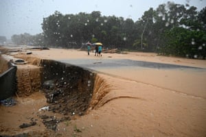 People walk along a flooded road in Toyos, Honduras, after the River Chirichil overflowed following heavy rains caused by Hurricane Eta