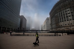 A security guard patrols in foggy conditions Canary Wharf, London, England