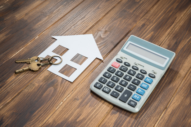 House keys and calculator on wooden floor