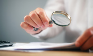 person using magnifying glass to read page